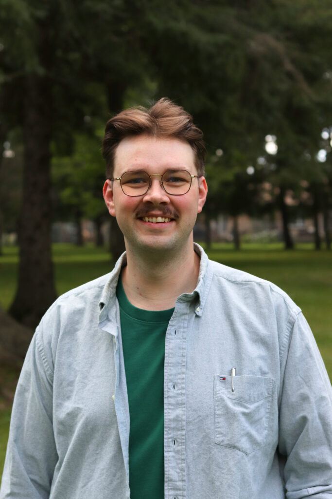 A headshot of the candidate Sam Hiemstra with blurred trees in the background.